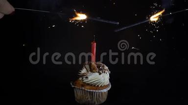 生日会盛宴庆祝理念.. 一个黑蜡烛的纸杯蛋糕。 烟火。 燃烧着烟雾的火花